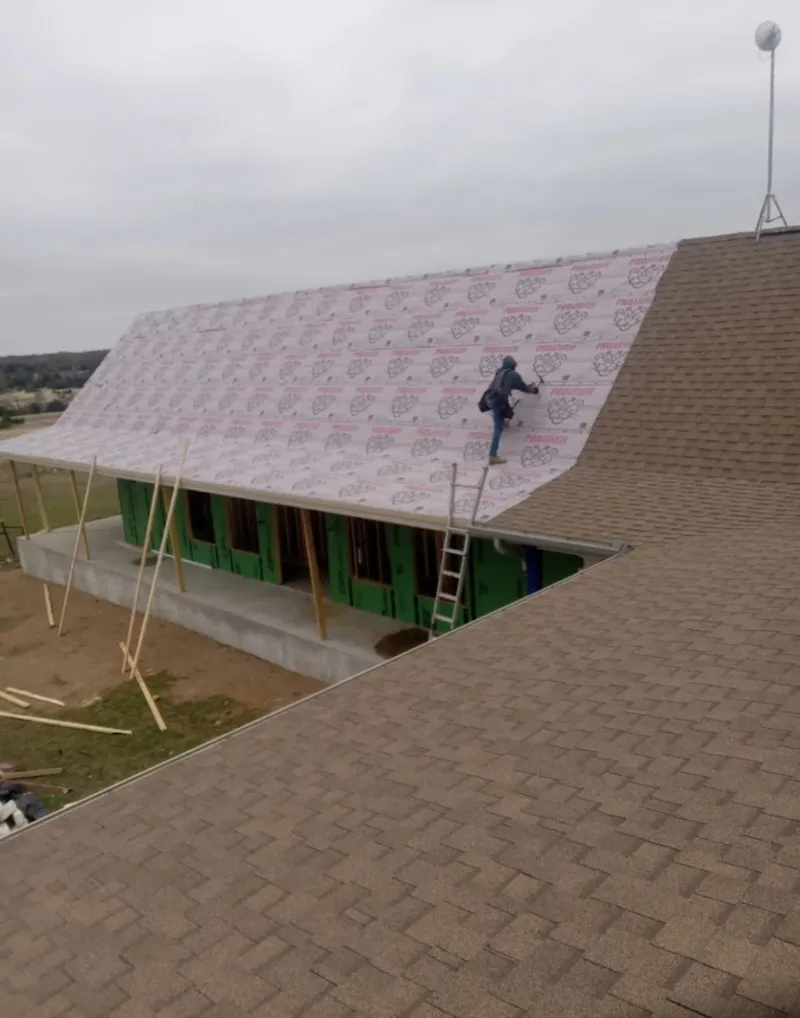 Worker preparing underlayment for a metal roof installation in Hopkinsville